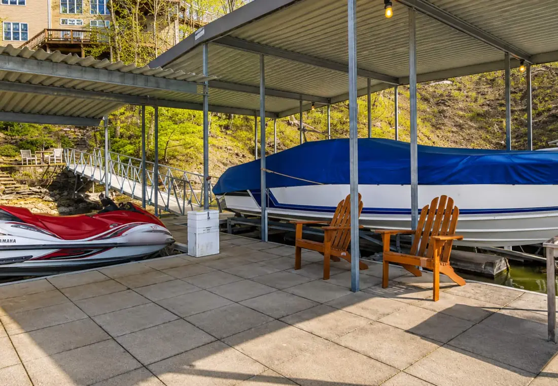 The swim platform under the covered dock, with chairs, the boat and the jet ski